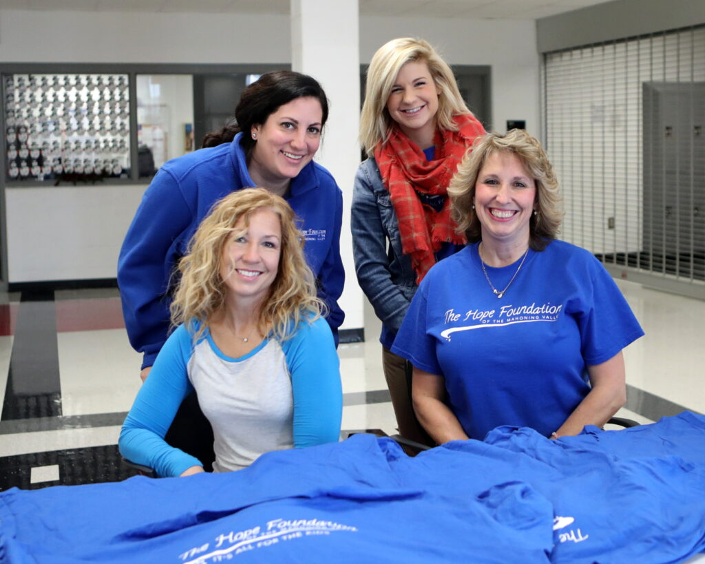Hope foundation members posing with promotional shirts