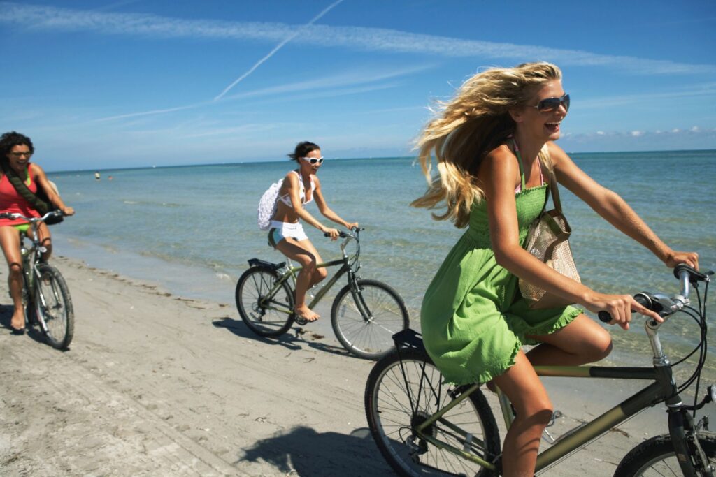 Three women enjoying a bike ride on the beach together
