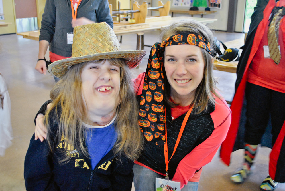 Two Smiling People Posing For A Photo With Headwear On